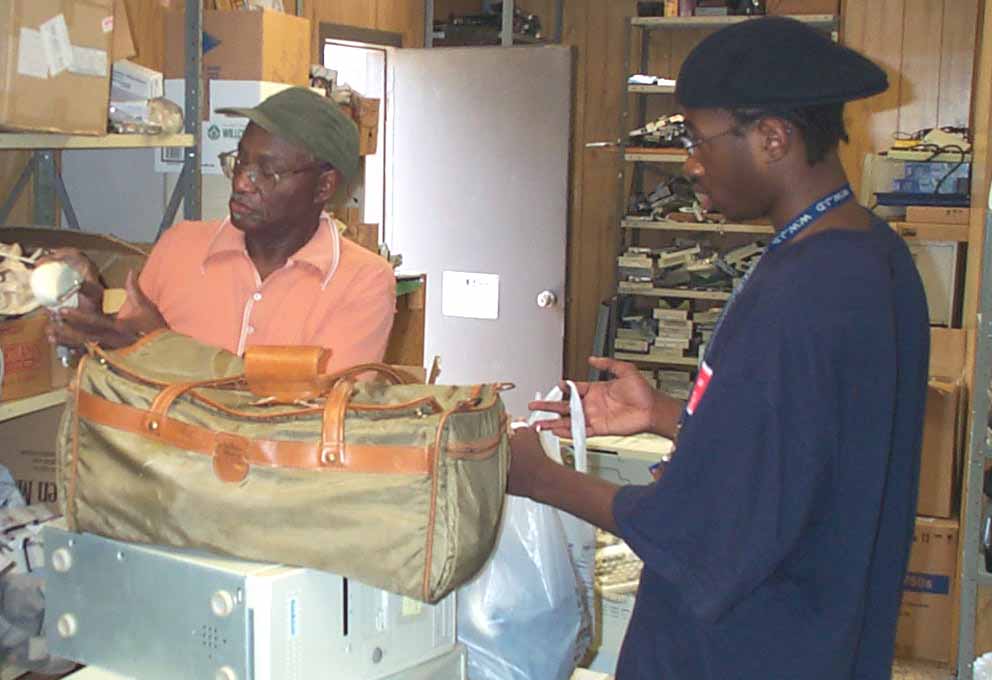 CAP volunteer Ken Eskridge getting mice for the new computers with help from Emmanuel Christian's Anthony Dunn